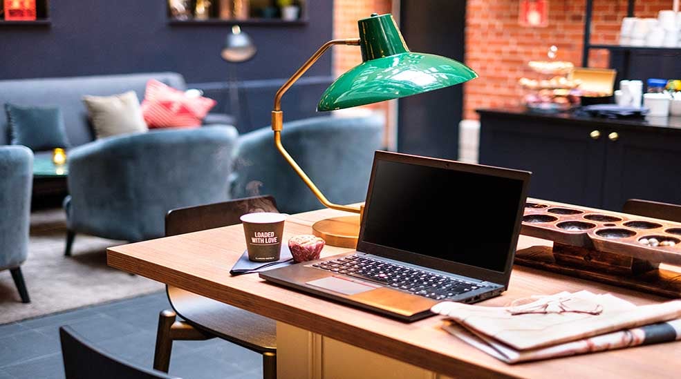 Working space in the lobby with a computer and lamp at Clarion Collection Hotel Temperance in Malmo