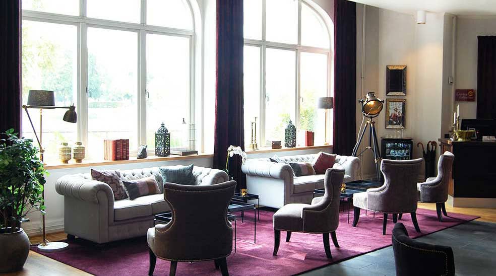 Lobby overview with chairs and sofas against the window at Clarion Collection Hotel Bolinder Munktell Eskilstuna