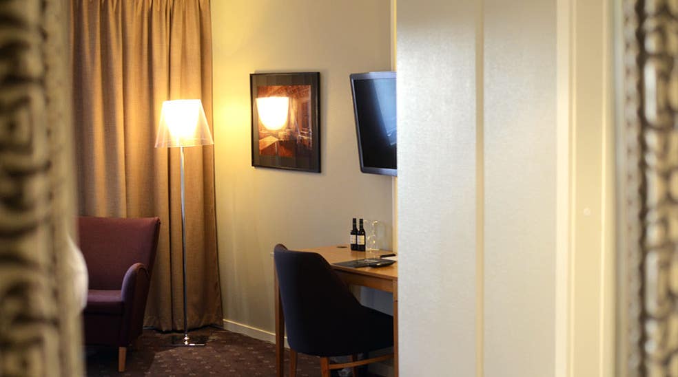 Desk with seating area and tv in superior room at Clarion Collection Hotel Kompaniet Nyköping