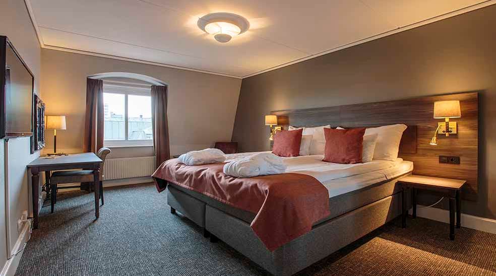 Suite double room with double bed and desk at Clarion Collection Hotel Uman Umeå