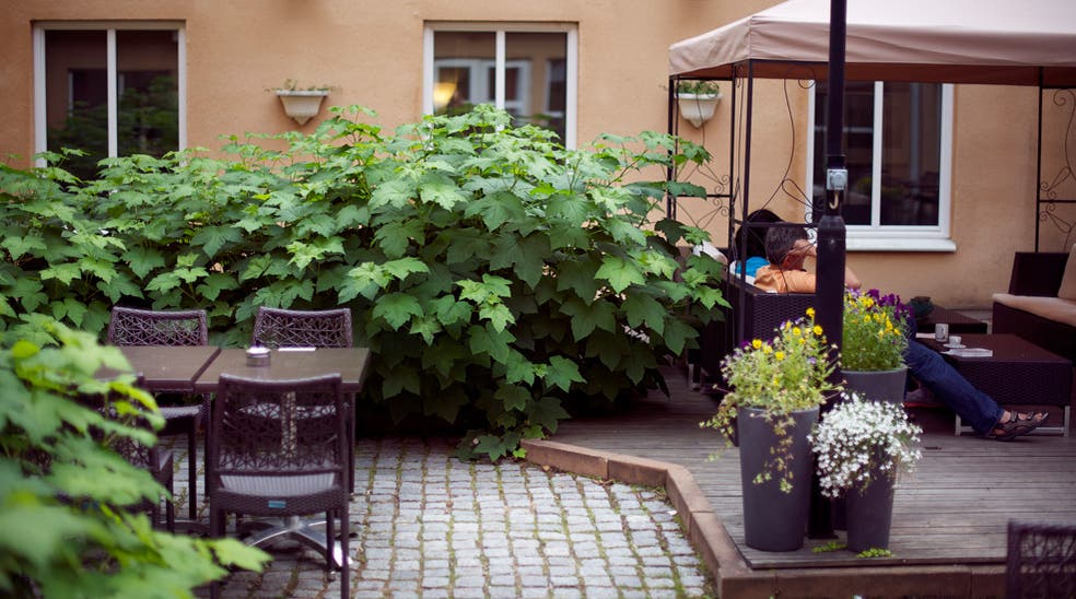 Green outdoor surrounding and comfortable seating at Uman Hotel in Umea