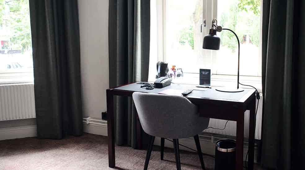 Suite with desk in front of window at Clarion Collection Hotel Victoria Jönköping
