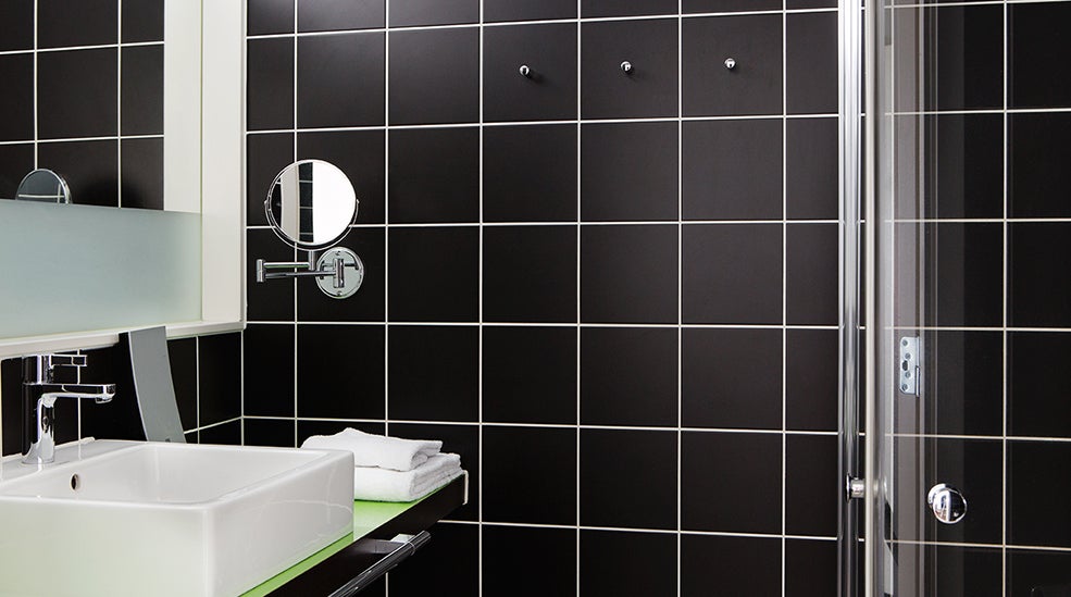 Bathroom with detales of sink, mirror and wall at Comfort Hotel Union Brygge Drammen