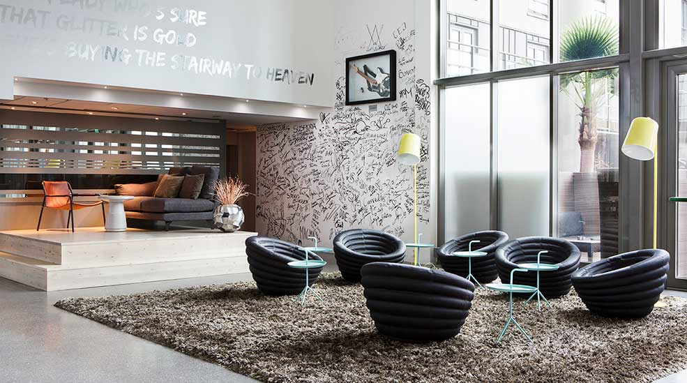 Lobby with a stage sofa and graffiti on the wall at Comfort Hotel Union Brygge in Drammen Norway