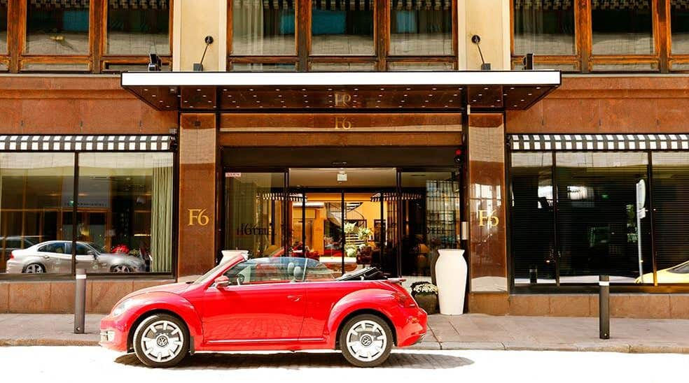 Red cabriolet parked in front of entrance to Hotel F6 in Helsinki, Finland