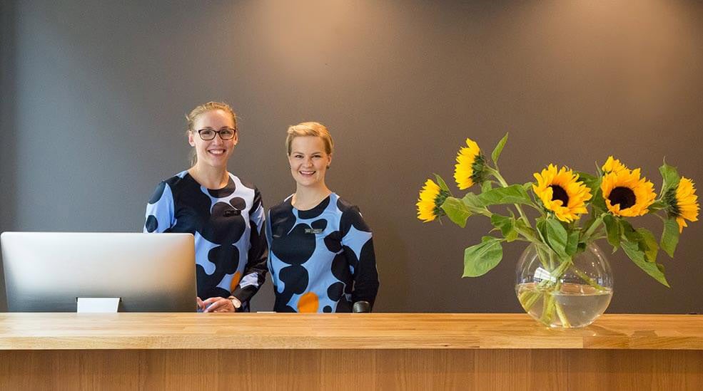 Two happy desk clerks at Hotel F6 in Helsinki, Finland