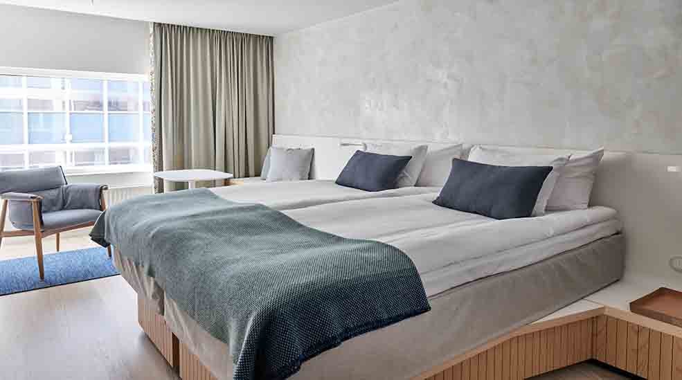 Double bed and chair in Scandinavian design in Superior Double hotel room with window at Nordic Light Hotel in Stockholm, Sweden