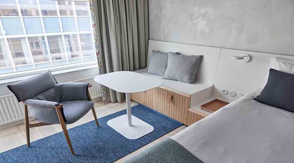 Seating area with table and chair in Scandinavian design in Superior Double hotel room with window at Nordic Light Hotel in Stockholm, Sweden