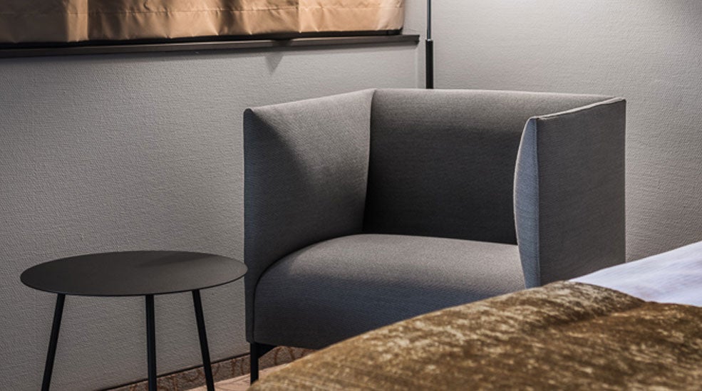 Grey armchair and black side table in a superior double room at the Quality Hotel Royal Corner