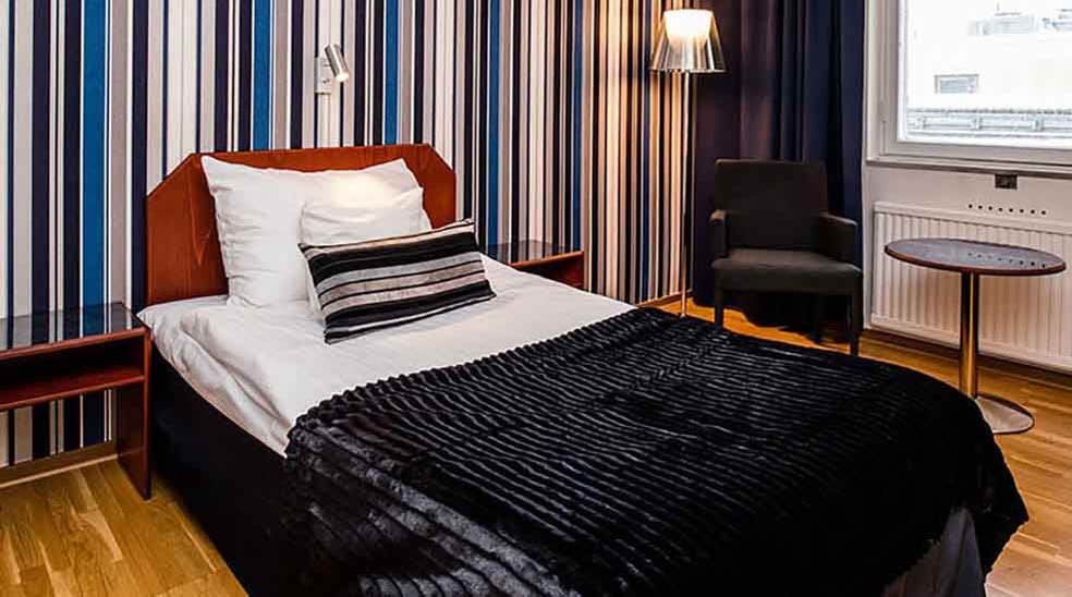 Moderate room with a bed and stripy wallpaper at the Quality Hotel Statt in Hudiksvall
