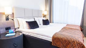 Standard double room with a double bed and pillows and bed spread at the Quality Hotel Winn Haninge